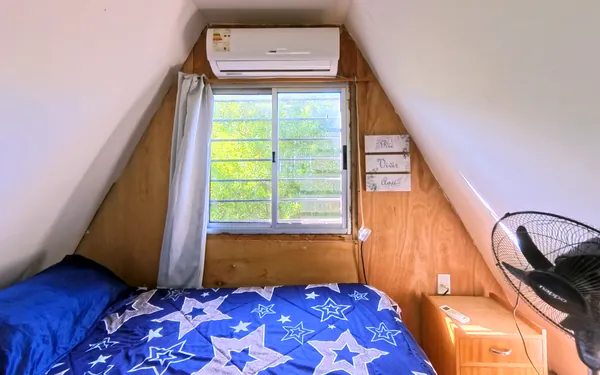 Dormitorio con aire acondicionado bajo el techo a dos aguas