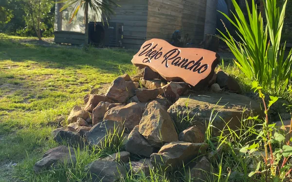 El cartel de Viejo Rancho frente a la cabaña, al atardecer